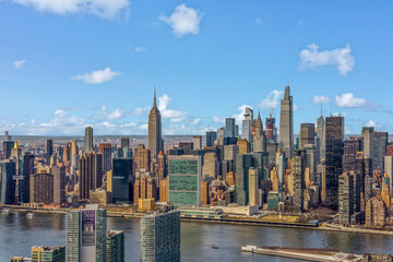 Aerial shot of midtown Manhattan Empire State Building One Vanderbilt Chrysler building FDR Drive East River blue sky 