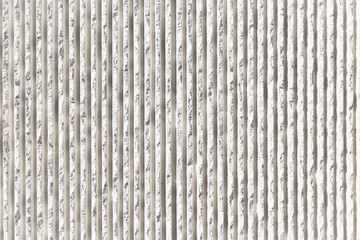 background of a concrete wall made of vertical white stripes