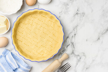 Dough for baking quiche tart pie in ceramic form. Culinary concept. Flat lay. Сopy space