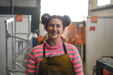 a portrait of a women welder holding a helmet and preparing for a working day in the metal industry