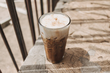 Iced cappuccino coffee drink in a tall glass. Concept of summer refreshment drink.