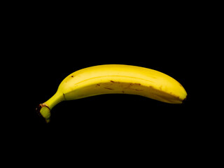 Close up of a ripe banana against a black background