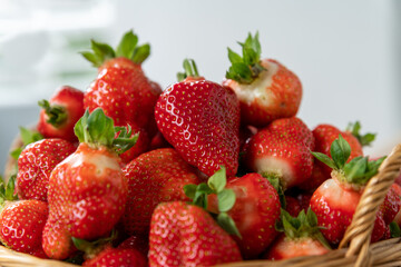 A cake with fruit on a plate. Group of strawberries in a basket.