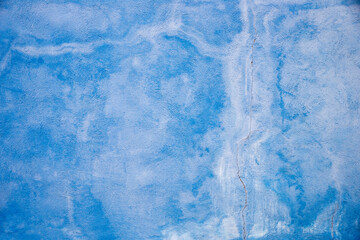 painted wall in washed-out shade of blue, with cracks, architectural vintage background