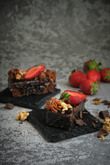 two chocolate cake with strawberries on a gray background