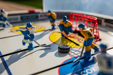 Table hockey. Players dressed in yellow and white.