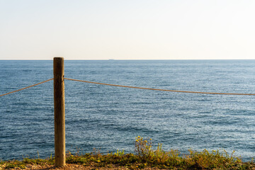 Mediterranean seascape, with a wooden pole crossed with a white rope.