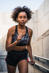Naklejka na ściany i meble Afro athlete woman running outdoors.