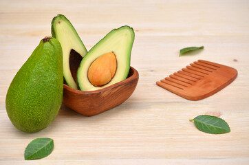 avocado fruit and wooden comb symbolizing hair beauty products