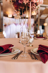 Champagne glasses. Candles and flowers. Banquet table decoration.