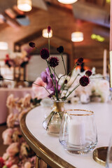 Champagne glasses. Candles and flowers. Banquet table decoration.