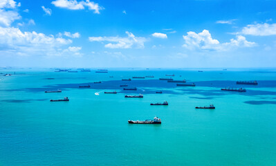 Fototapeta na wymiar Aerial view of container ships in Singapore Strait. Airplane shot. Cargo ships anchored in the road, waiting to enter the busiest port in region. 