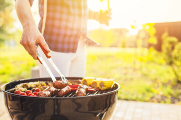Man working on the grill, man doing barbecue for friends on the grill, outdoor, barbecue party