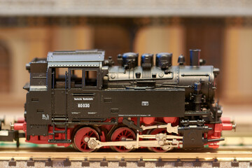 Old model train in front of a toy station, one of the most popular hobbies in the world in the past...