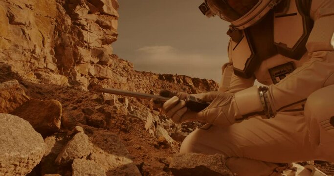 Unrecognizable astronaut analyzing soil of Mars