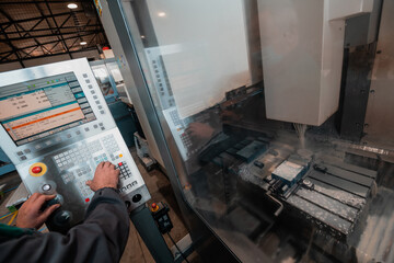 close up a worker hand or engineer introducing a program into a modern CNC machine. The concept of industry and engineering.