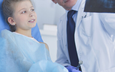 Obraz premium Little girl sitting in the dentists office