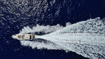 Aerial drone top down photo of luxury yacht with wooden deck cruising in the Aegean deep blue sea, Greece
