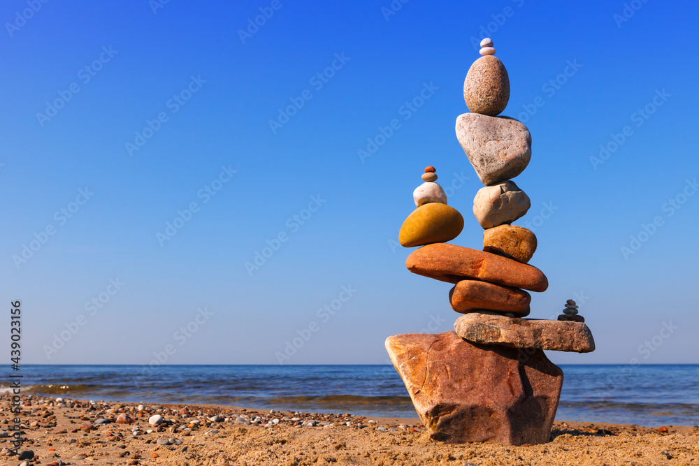 Wall mural Rock zen pyramid of colorful stones on the beach. Concept of Life balance and meditation