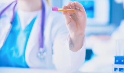 Laboratory assistant holding test tube, Close-up view focused on the test tube.