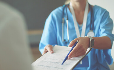 Female doctor hand hold silver pen filling patient history list at clipboard pad