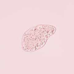 Hyaluronic acid serum texture. Beauty skin care liquid gel on pastel pink background. Clear...