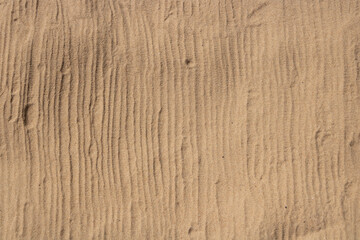 The print of the stripes on the sand from the recreation mat