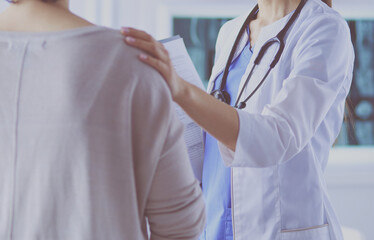 Medical consultation. Female doctor holding a patient by her shoulder, soothing her fear - 439025595