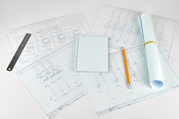Naklejka na ściany i meble Printed electrical diagrams, a notebook for writing, a pencil and a ruler. Engineer's workplace. Concept of engineering works, project organization plan.