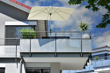 Begrünter Balkon mit Edelstahl-Sichtschutz und Edelstahl-Geländer an einer Neubau-Hausfront