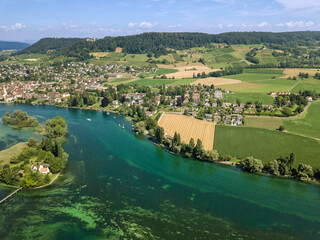 Drone image of village and farming land at the blue Rhine river side with Swiss town Stein am Rhein at the background