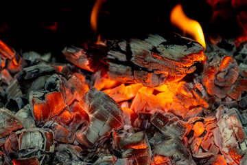 Background of red and black burning coals close-up for design.