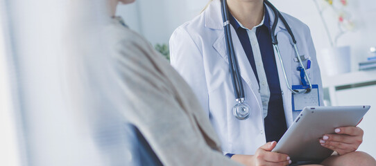Doctor and patient discussing something while sitting at the table . Medicine and health care concept
