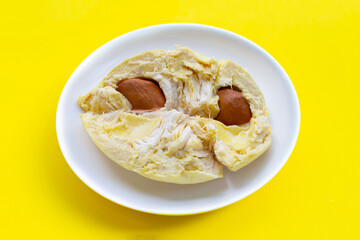Durian in white plate on yellow background.