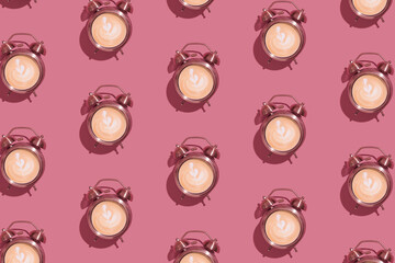 Alarm clock with foamy coffee pattern with hard shadows. Morning rise with coffee for breakfast concept