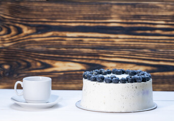 White curd torso with blueberry decoration.next to a white cup and saucer.space for text. High quality photo