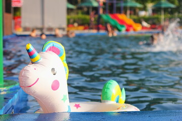 A swimming circle in the form of a unicorn is floating in the pool.