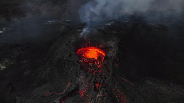 Aerial footage of an icelandic volcano erupting in 2021 in Reykjanes peninsula, shot at dusk with contrast with black lava landscape and red hot lava. High quality 4k footage