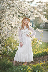 A beautiful girl in a hat among the flowering trees 2724.
