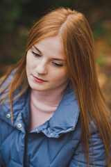 A large portrait of a red-haired girl against the background of nature 2749