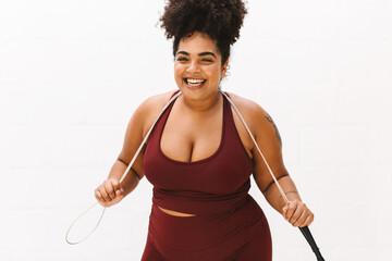 Positive woman holding skipping rope