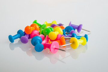 office buttons have multi-colored plastic handles, the shape of which is similar to a cylinder with...