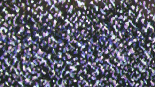 Close up view at a plasma tv while showing white noise .