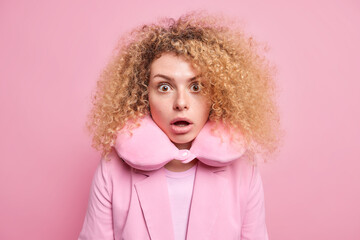 Indoor shot of shocked woman with curly bushy hair stares embarrassed at camera keeps mouth wide...