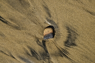 A cream and brown piece of ceramics cast away on the beach, jetsam and flotsam,  candid image of...
