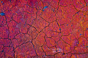 Rusty red cracked soil rich in iron ore, extremely warm sunset light, small lava stones and pebbles.
