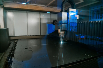 Sparks fly out machine head for metal processing laser metal on metallurgical plant background. Manufacturing finished parts for automotive production concept