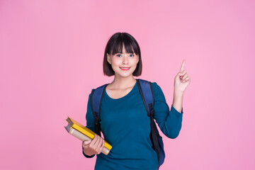 Asian Student cute girl happy smiling smart holding books bag pack learning research studying information communication languages pink isolated background school college university academic education