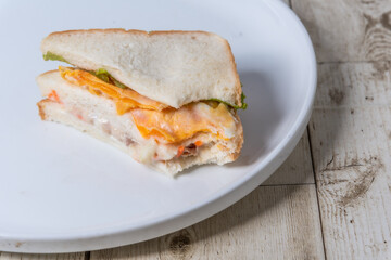 Sandwiches in white plates on wooden floor