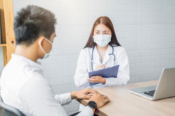 Asian Medical healthcare clinic doctor examining diagnosing male patient clipboard writing wearing surgical mask protection infection disease, working at home modern office technology computer laptop